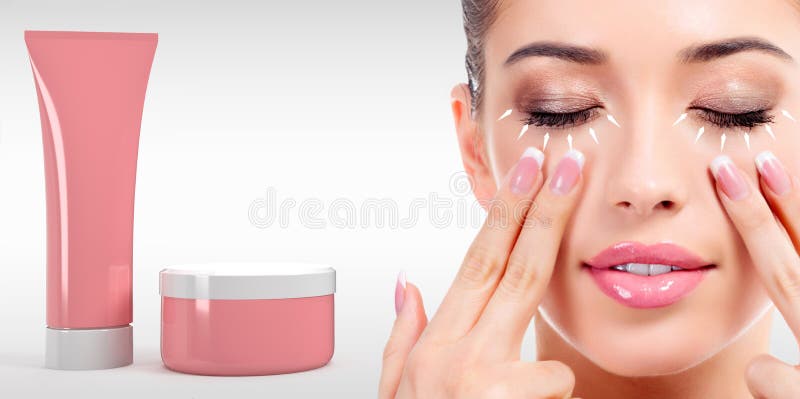 Frau, die ihr Gesicht mit den Fingern und den Kosmetik Rohr und Glas massiert lizenzfreies stockbild Frau, die ihr Gesicht mit den Fingern und den Kosmetik Rohr und Glas massiert lizenzfreies stockbild