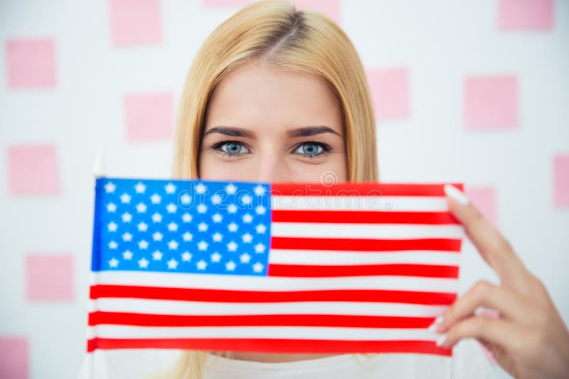 Frau, die ihr Gesicht mit USA-Flagge bedeckt lizenzfreie stockbilder Frau, die ihr Gesicht mit USA-Flagge bedeckt lizenzfreie stockbilder