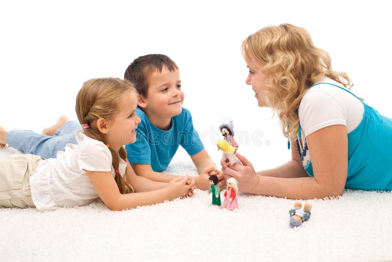 Frau, die ihren Kindern auf dem Fußboden eine Geschichte erklärt stockbild Frau, die ihren Kindern auf dem Fußboden eine Geschichte erklärt stockbild