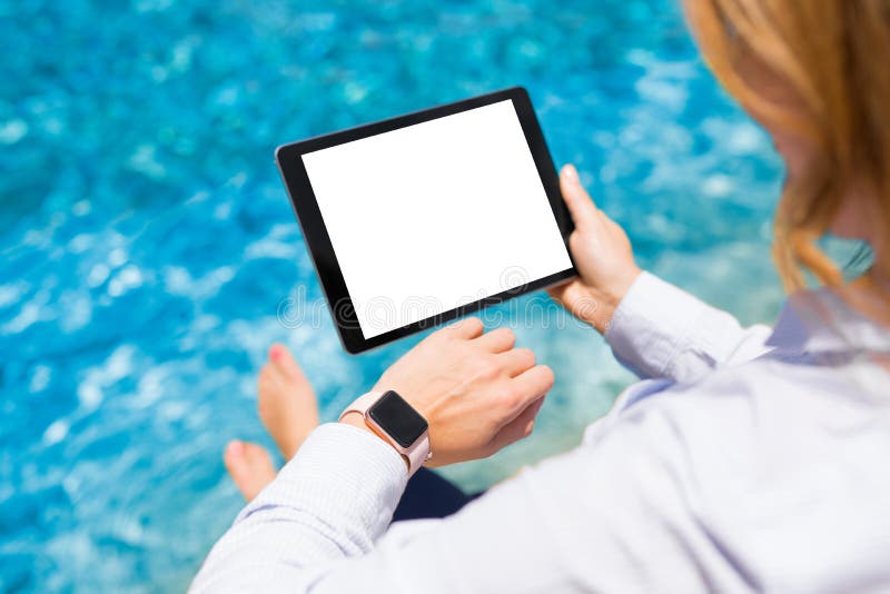 Frau, die im Urlaub moderne Technologiegeräte durch das Pool verwendet lizenzfreie stockbilder