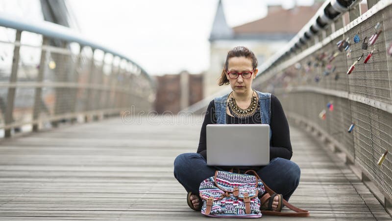 Frau, die an Laptop beim Sitzen auf der Straße arbeitet Das Konzept des Arbeitsfreiberuflers oder des Blogger stockbilder Frau, die an Laptop beim Sitzen auf der Straße arbeitet Das Konzept des Arbeitsfreiberuflers oder des Blogger stockbilder