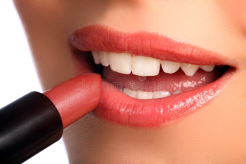 Frau, die Lippenstiftschönheitskosmetik auf Lippen zutrifft