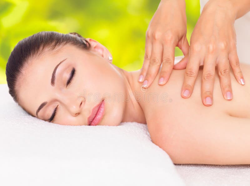 Frau, die Massage des Körpers im Naturbadekurort hat lizenzfreie stockbilder Frau, die Massage des Körpers im Naturbadekurort hat lizenzfreie stockbilder