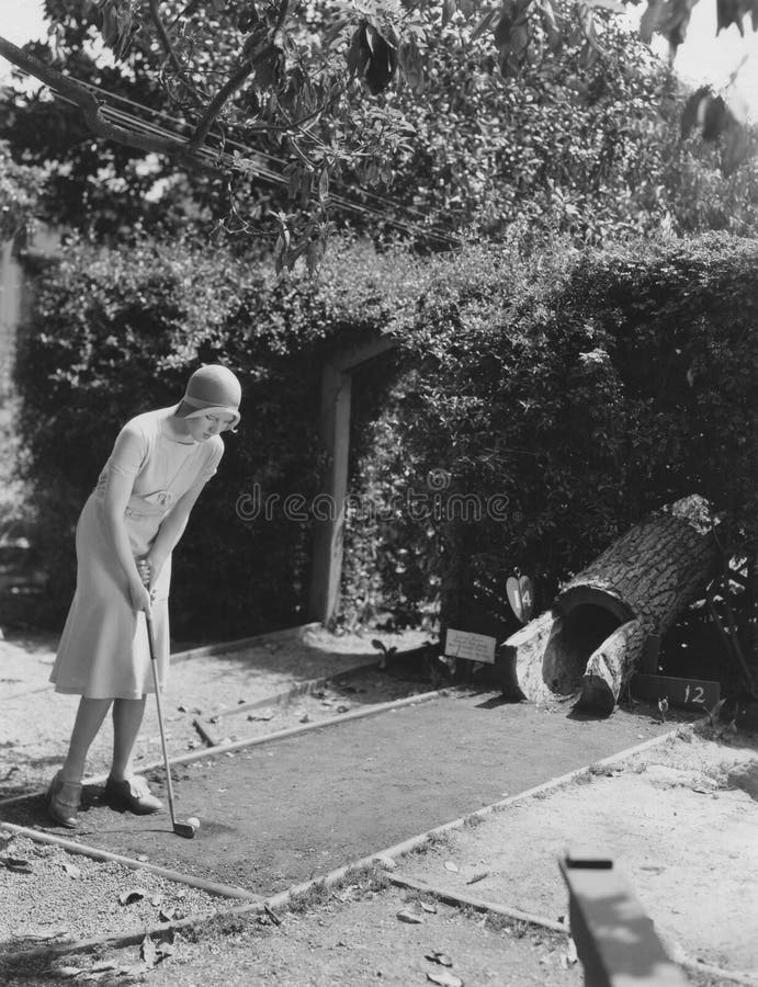 Frau beim Minigolf spielen stockbilder
