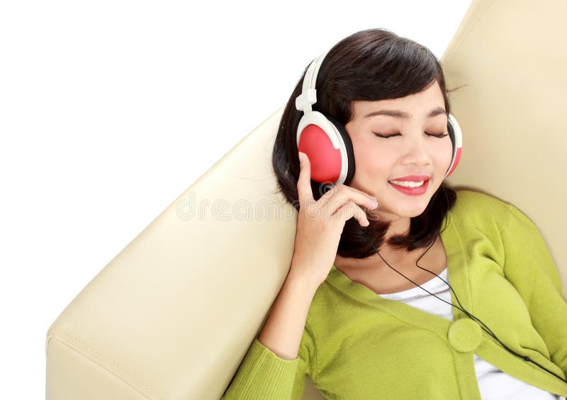 Young attractive woman enjoying music with headphone on the couch. Young attractive woman enjoying music with headphone on the couch