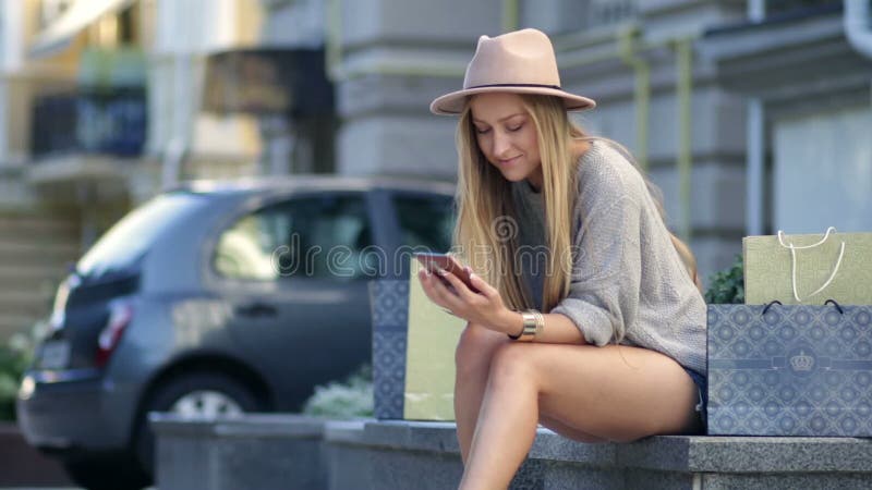 Frau, die online unter Verwendung des Handys im Freien kauft