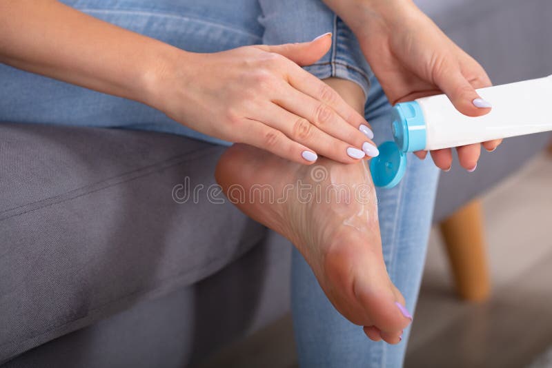 Frau, die Sahne auf ihren F??en auftr?gt stockbild Frau, die Sahne auf ihren F??en auftr?gt stockbild