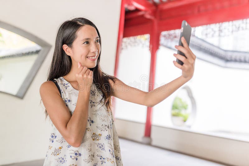 Frau, die selfie im chinesischen Garten nimmt lizenzfreies stockbild Frau, die selfie im chinesischen Garten nimmt lizenzfreies stockbild