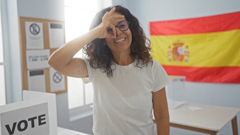 Frau, die vor dem Wahlmännergremium mit spanischer Flagge im Hintergrund eine Geste macht stockbilder