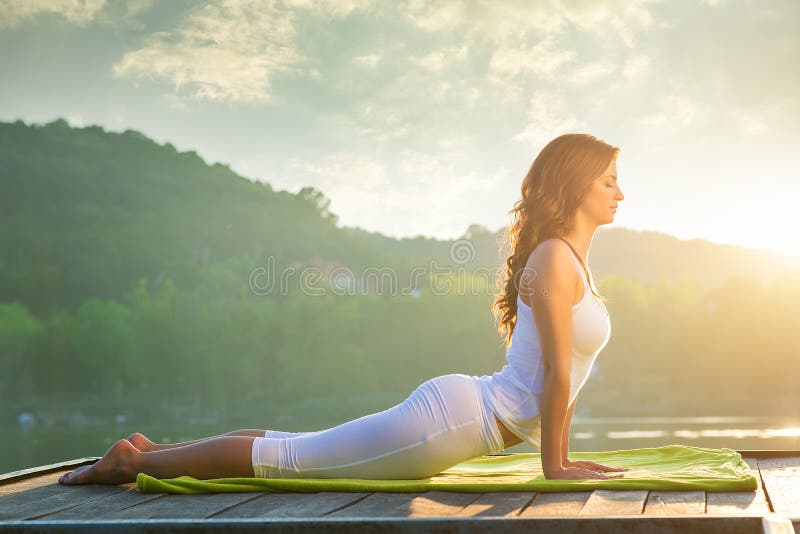 Frau, die Yoga auf dem See tut stockfotografie