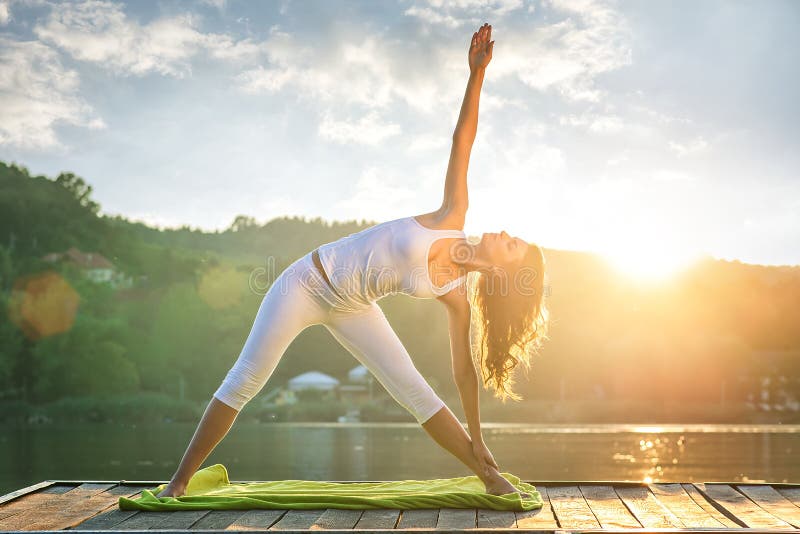 Frau, die Yoga auf dem See tut stockbilder