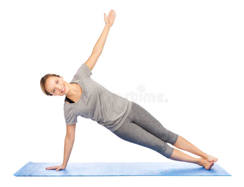 Frau, die Yoga in der Seitenplankenhaltung auf Matte macht stockbilder Frau, die Yoga in der Seitenplankenhaltung auf Matte macht stockbilder