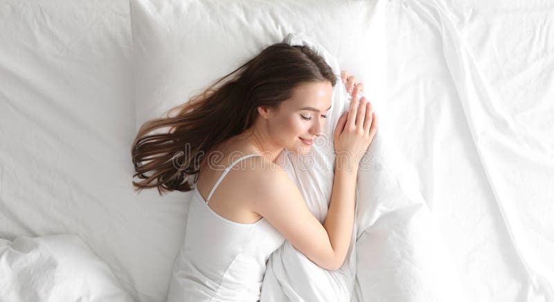 Frau, die zu Hause auf komfortablen Beutel in der Draufsicht des Betts schläft.