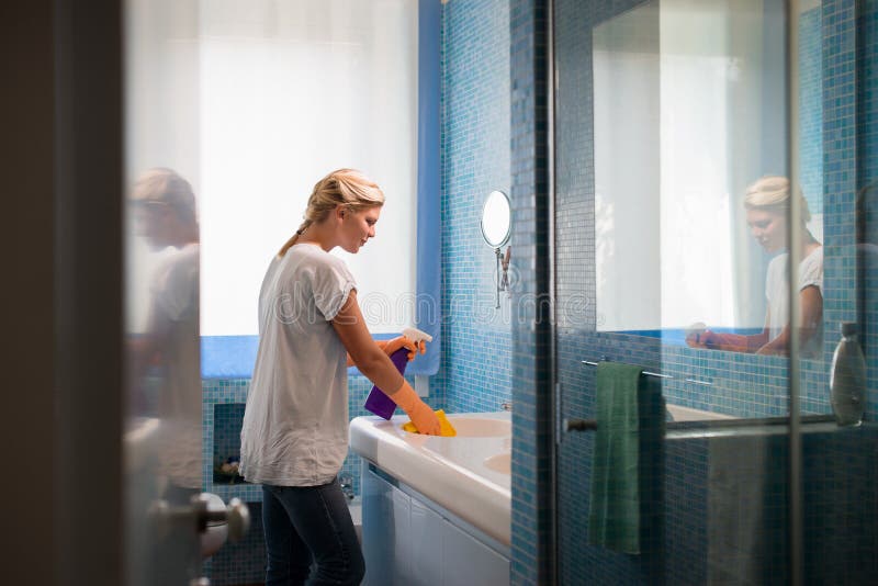 Frau, die zu Hause Aufgabe- und Reinigungsbadezimmer tut lizenzfreies stockbild