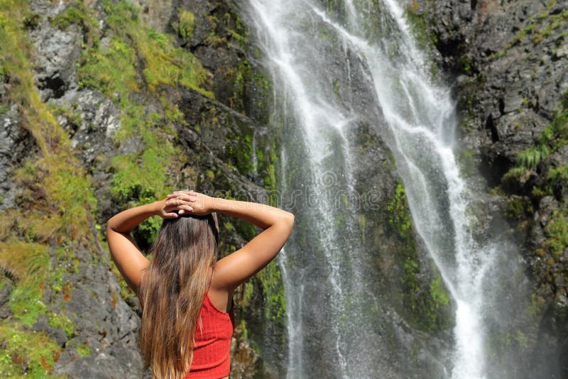 Frau, die über den Wasserfall im Berg nachdenkt