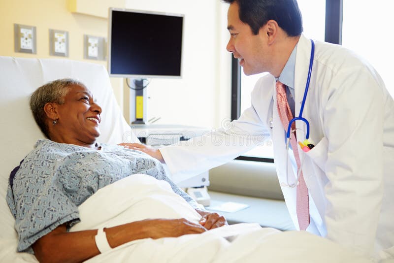 Frau Doktor-Talking To Senior im Krankenhauszimmer lizenzfreies stockfoto Frau Doktor-Talking To Senior im Krankenhauszimmer lizenzfreies stockfoto