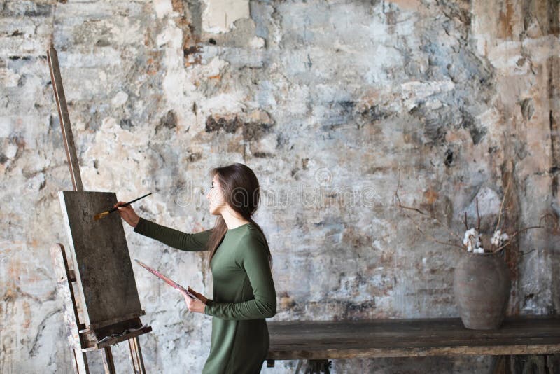 Frau in einem Kunststudio beim Zeichnen auf ein Segeltuch lizenzfreies stockbild Frau in einem Kunststudio beim Zeichnen auf ein Segeltuch lizenzfreies stockbild