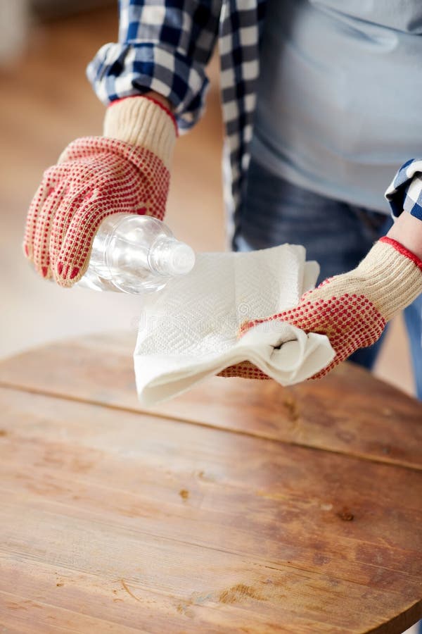 furniture renovation, diy and home improvement concept - close up of woman degreasing old round wooden table surface with solvent and paper. furniture renovation, diy and home improvement concept - close up of woman degreasing old round wooden table surface with solvent and paper