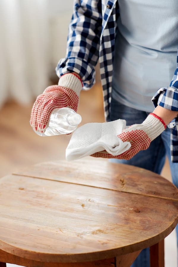 furniture renovation, diy and home improvement concept - close up of woman degreasing old round wooden table surface with solvent and paper. furniture renovation, diy and home improvement concept - close up of woman degreasing old round wooden table surface with solvent and paper