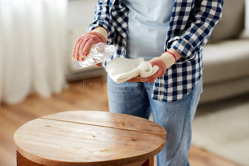 furniture renovation, diy and home improvement concept - close up of woman degreasing old round wooden table surface with solvent and paper. furniture renovation, diy and home improvement concept - close up of woman degreasing old round wooden table surface with solvent and paper