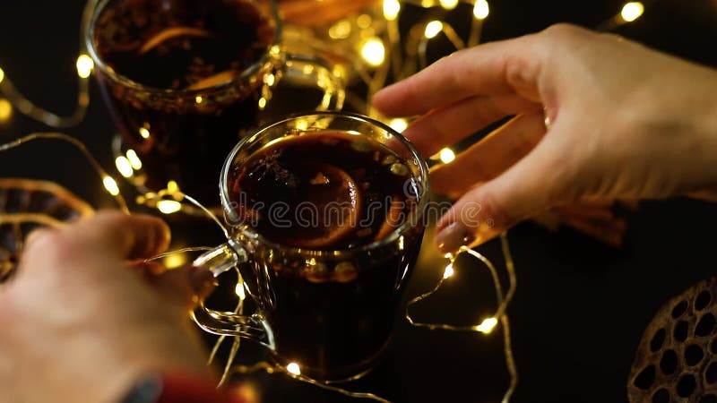 Frau Hand setzen Tasse Weihnachtswein pantomelierten Rotwein mit Gewürzen und Orangen