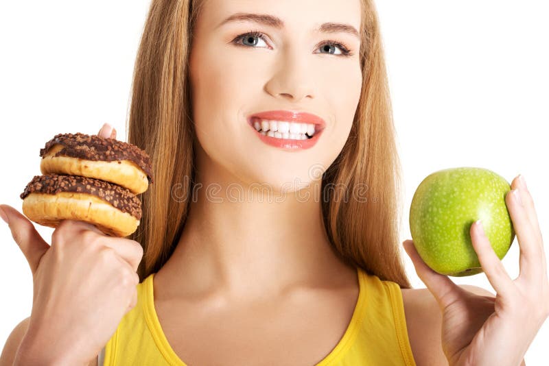 Frau hat eine harte Wahl zwischen Donut und Apfel stockbilder Frau hat eine harte Wahl zwischen Donut und Apfel stockbilder