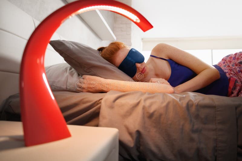 Frau im Bett schlafend mit Schlaf-Maske auf Augen lizenzfreie stockbilder Frau im Bett schlafend mit Schlaf-Maske auf Augen lizenzfreie stockbilder