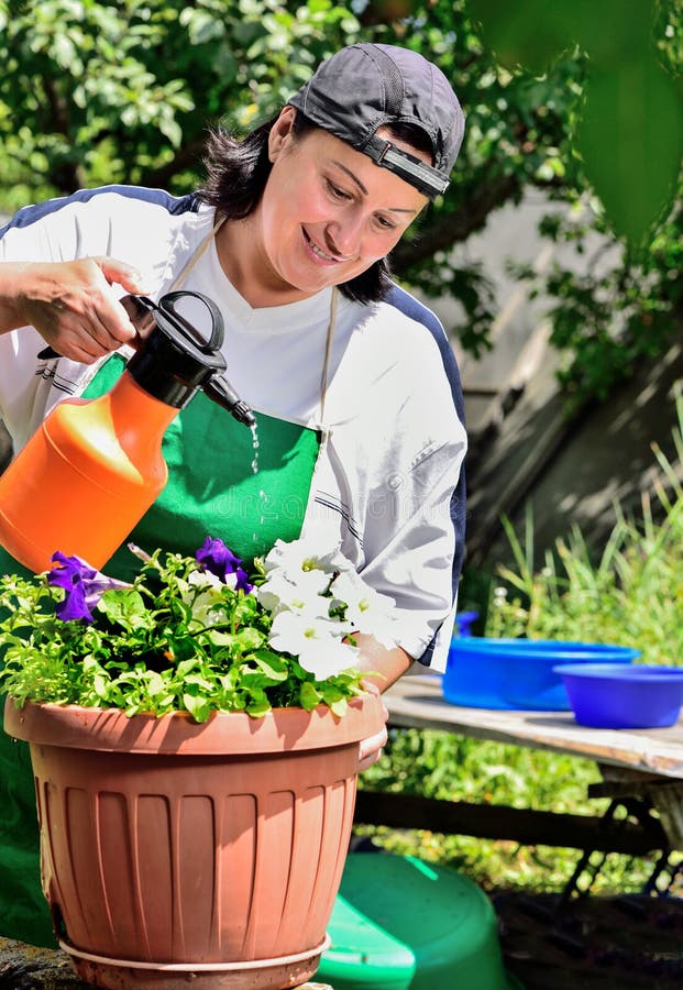 Frau im Garten mit Blumen stockfoto. Bild von arbeit 75239092