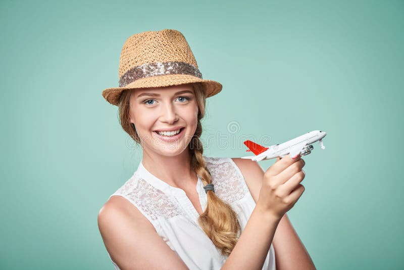 Frau im Strohhut, der in der Hand Flugzeugmodell hält stockfoto Frau im Strohhut, der in der Hand Flugzeugmodell hält stockfoto