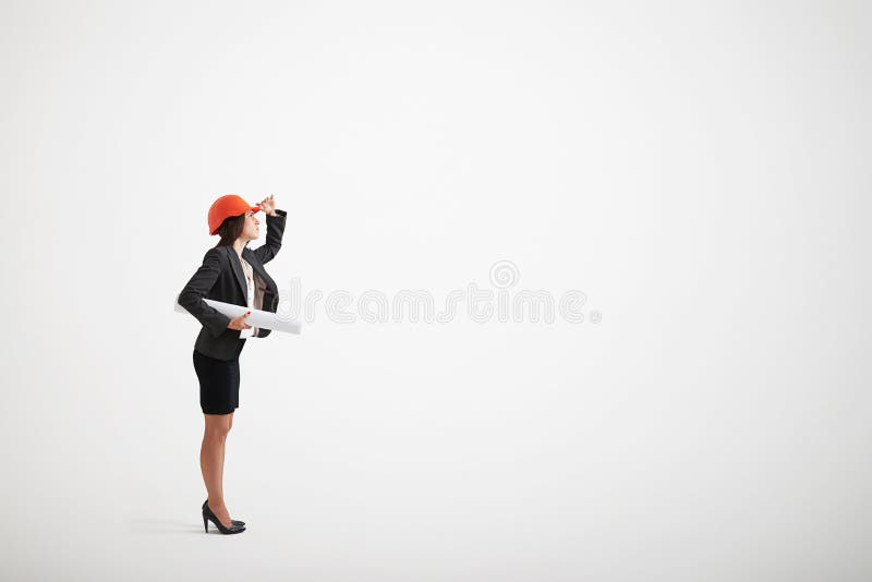 Frau im Sturzhelm der formellen Kleidung und des Baus, der Pläne hält lizenzfreies stockbild Frau im Sturzhelm der formellen Kleidung und des Baus, der Pläne hält lizenzfreies stockbild