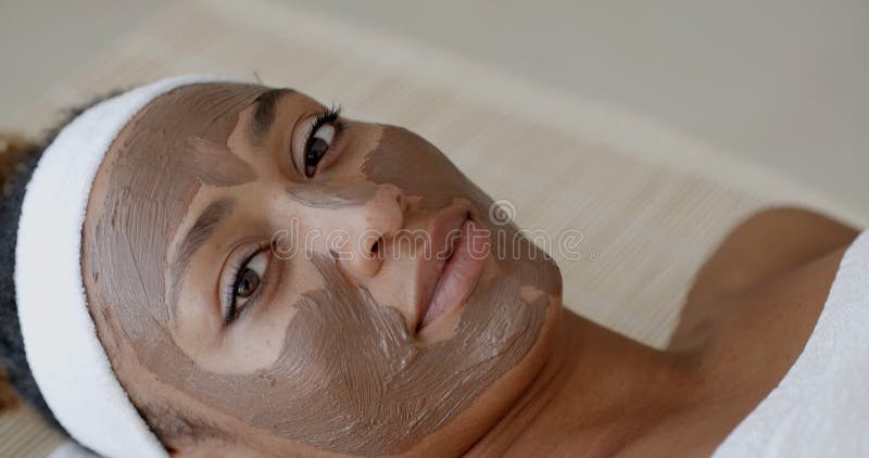 Frau mit Clay Facial Mask In Spa