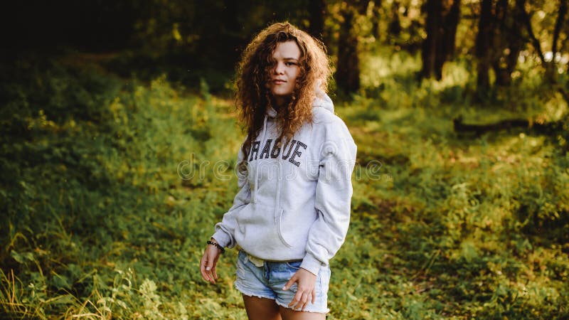 Frau mit dem gelockten Haar, der Romance von Jugend, ein Reiseweg an einem sonnigen Tag des warmen Sommers auf einem sandigen Str lizenzfreies stockbild Frau mit dem gelockten Haar, der Romance von Jugend, ein Reiseweg an einem sonnigen Tag des warmen Sommers auf einem sandigen Str lizenzfreies stockbild
