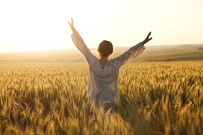 Woman with arms outstretched in a wheat field. Woman with arms outstretched in a wheat field