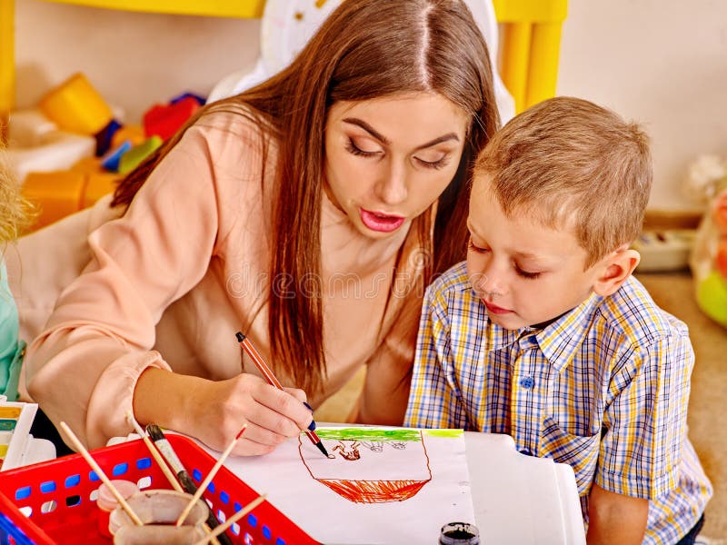 Frau mit den Kindern, die herein farbiges Papier und Kleber halten stockbild Frau mit den Kindern, die herein farbiges Papier und Kleber halten stockbild