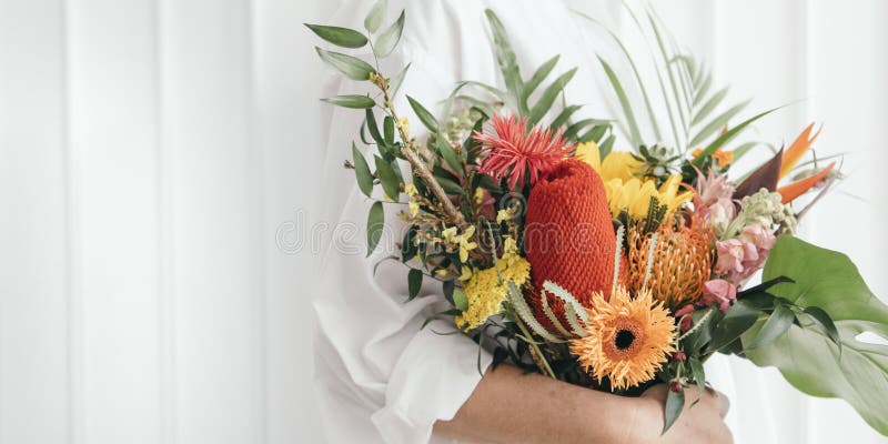 Frau, die einen bunten tropischen Blumenstrauß hält lizenzfreie stockfotografie