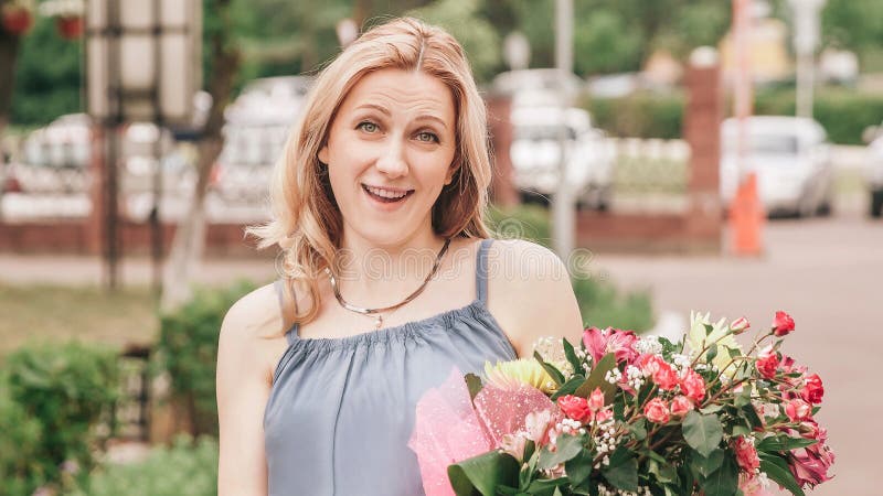Frau mit einem Strauß von Blumen, die auf einer Straßen werden stockfotos