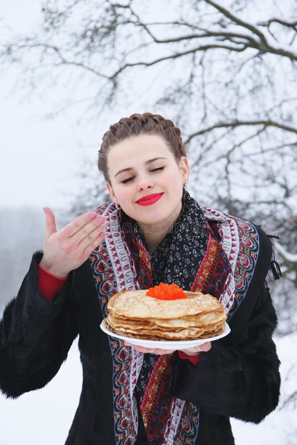 Frau mit einer Platte von Pfannkuchen und von Kaviar lizenzfreie stockbilder Frau mit einer Platte von Pfannkuchen und von Kaviar lizenzfreie stockbilder