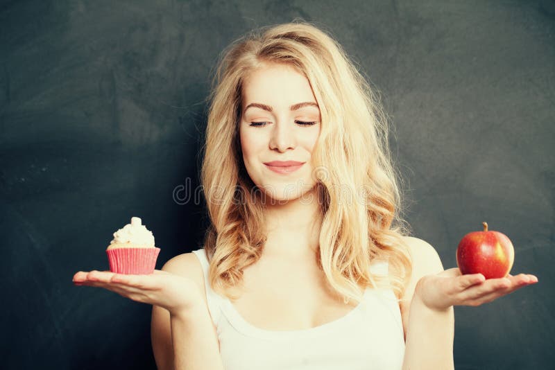 Frau mit gesundem und ungesundem Lebensmittel Schwierige Wahl stockfoto Frau mit gesundem und ungesundem Lebensmittel Schwierige Wahl stockfoto
