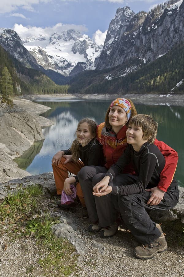 Frau mit Kindern in einem See in den Bergen stockbild Frau mit Kindern in einem See in den Bergen stockbild