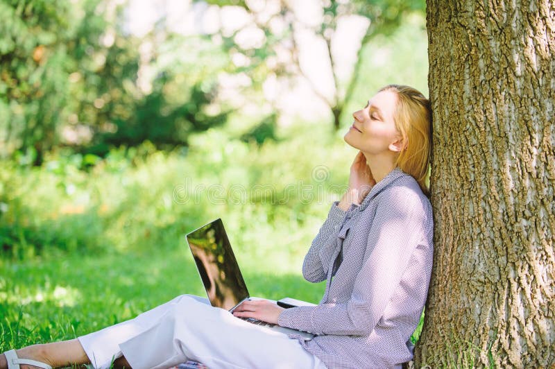 Woman with laptop work outdoors lean tree. Minute for relax. Education technology and internet concept. Girl work with laptop in park sit on grass. Natural environment office. Work outdoors benefits. Woman with laptop work outdoors lean tree. Minute for relax. Education technology and internet concept. Girl work with laptop in park sit on grass. Natural environment office. Work outdoors benefits.