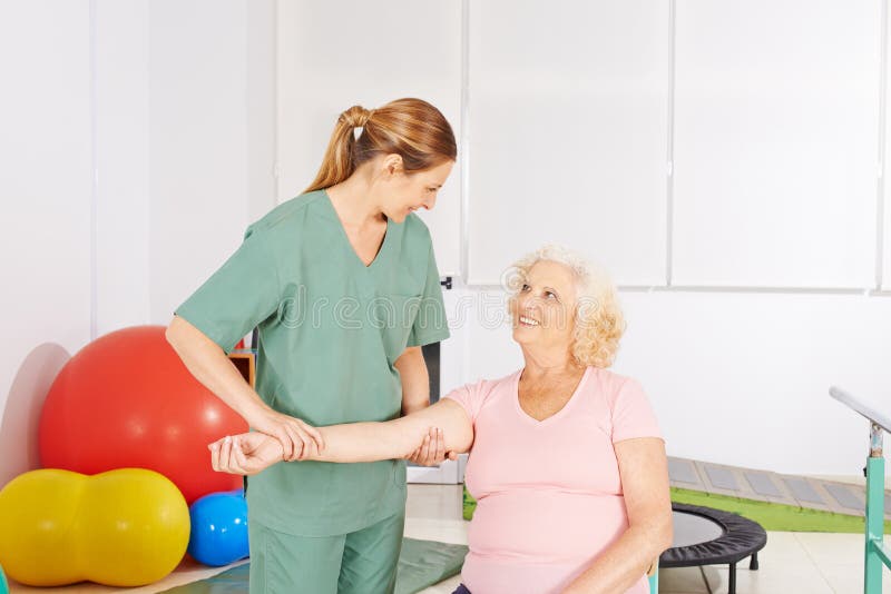 Frau mit schmerzender Schulter in der Physiotherapie lizenzfreies stockbild Frau mit schmerzender Schulter in der Physiotherapie lizenzfreies stockbild