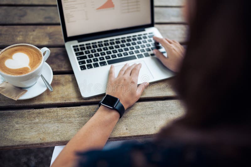 Frau mit smartwatch unter Verwendung des Laptops am Café stockfoto Frau mit smartwatch unter Verwendung des Laptops am Café stockfoto