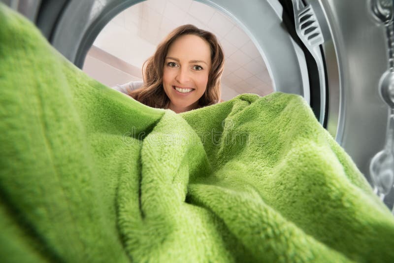 Frau mit Tuch-Innenansicht die Waschmaschine stockfoto