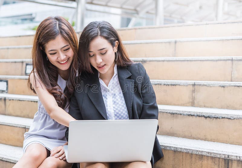 Frau mit zwei Asiaten, die den Computer im Freien verwendet stockfotos Frau mit zwei Asiaten, die den Computer im Freien verwendet stockfotos