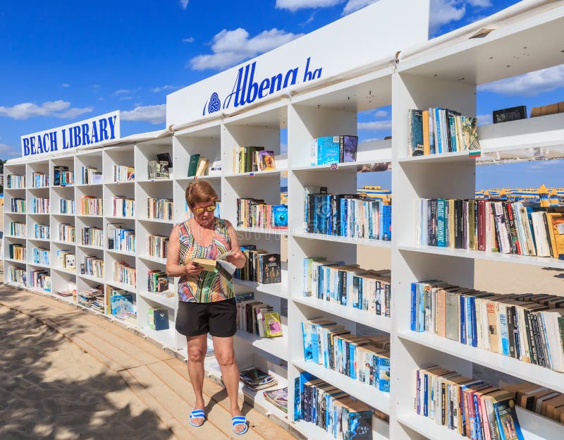 Frau nahe freier Strandbibliothek öffnete sich am Erholungsort Schwarzen Meers von lizenzfreies stockfoto Frau nahe freier Strandbibliothek öffnete sich am Erholungsort Schwarzen Meers von lizenzfreies stockfoto