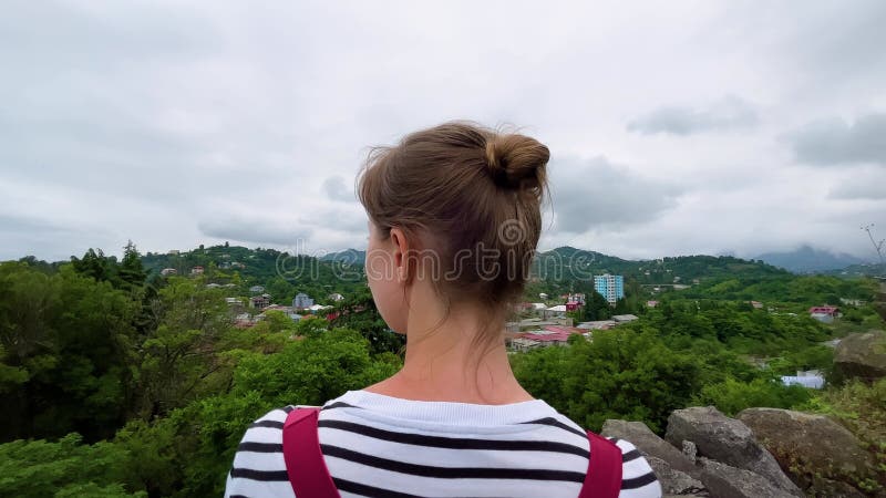 Frau schaut sich georgische Landschaft mit Bergen und ländlichen Häusern an