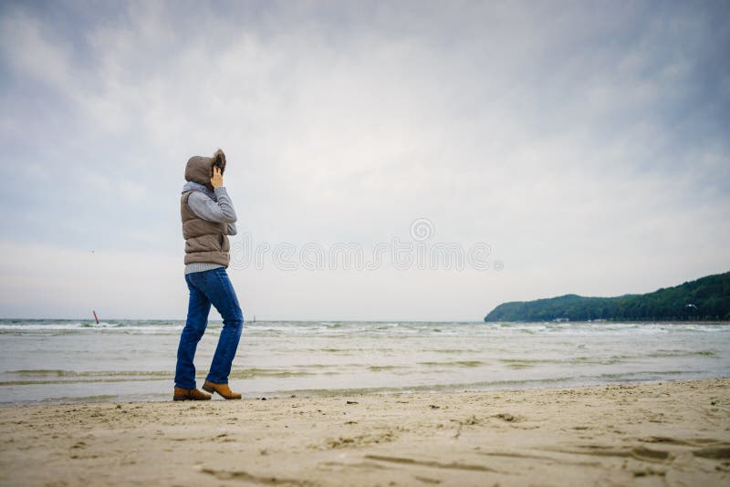Frau am Strand Herbstkalter Tag lizenzfreie stockfotos