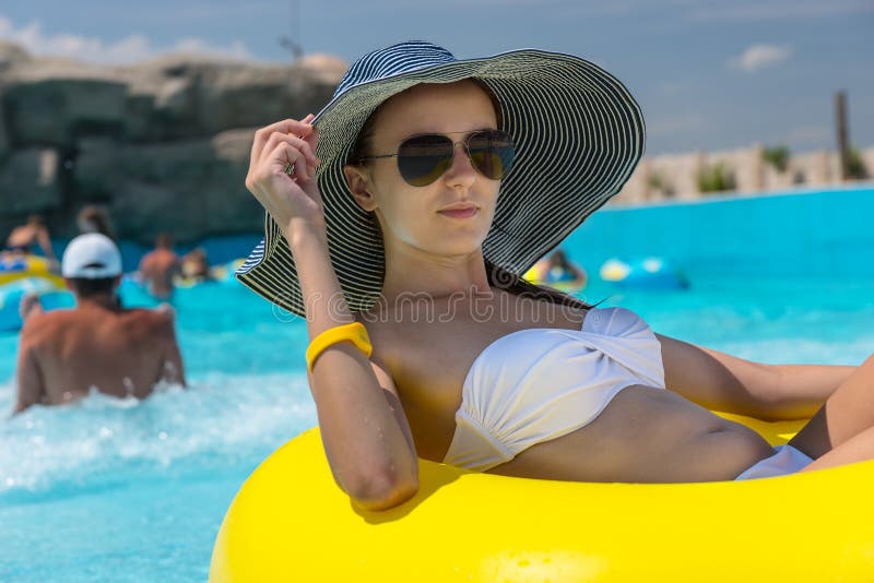 Frau in Sun-Hut, der in Pool-inneres Rohr schwimmt stockfoto Frau in Sun-Hut, der in Pool-inneres Rohr schwimmt stockfoto