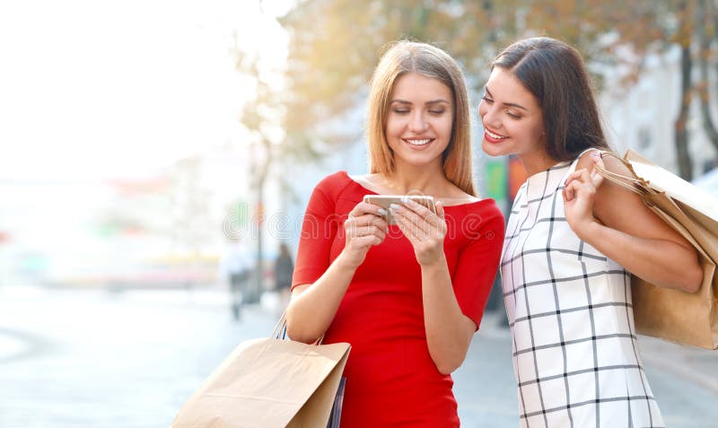 Frau zeigt seiner Freundin an einem Handy etwas lizenzfreie stockbilder Frau zeigt seiner Freundin an einem Handy etwas lizenzfreie stockbilder