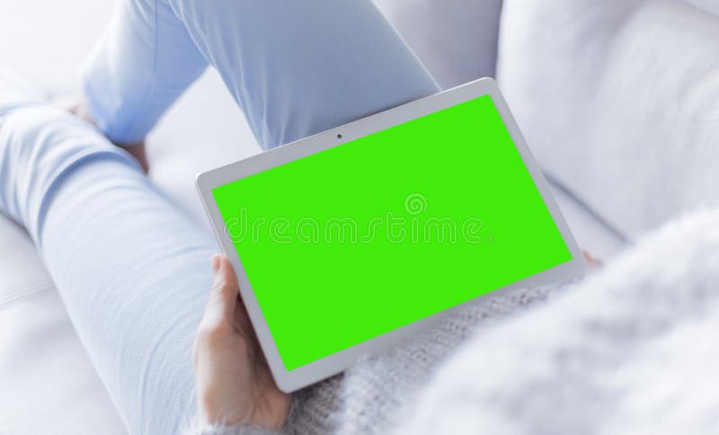 Frau zu Hause, die Lesung auf dem Tablet-Computer sich entspannt lizenzfreies stockbild Frau zu Hause, die Lesung auf dem Tablet-Computer sich entspannt lizenzfreies stockbild